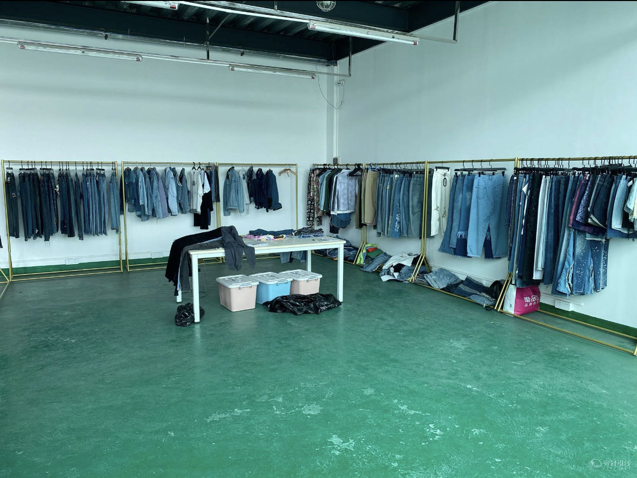 First view of the showroom with denim samples displayed on racks